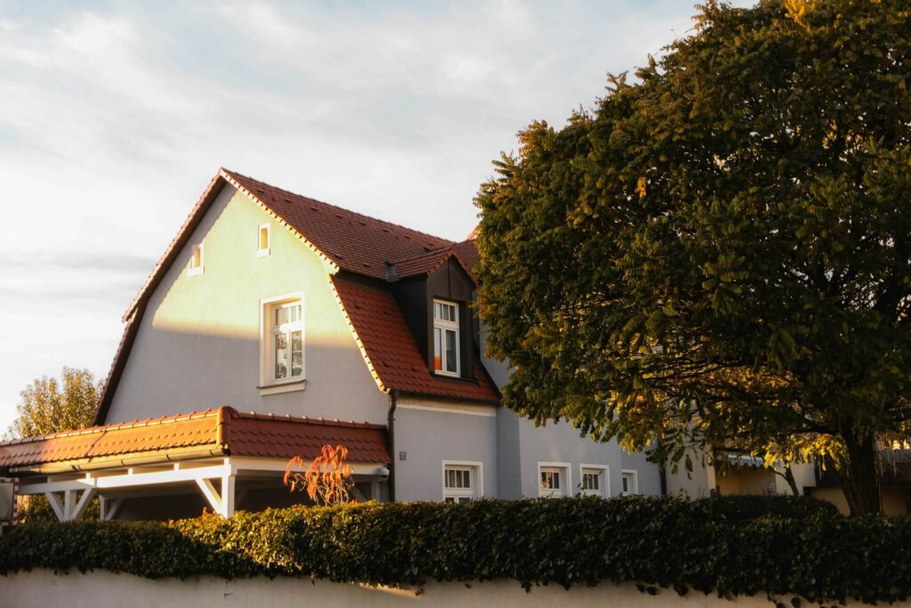 Stort vitt hus med en stort grönt träd vid sidan