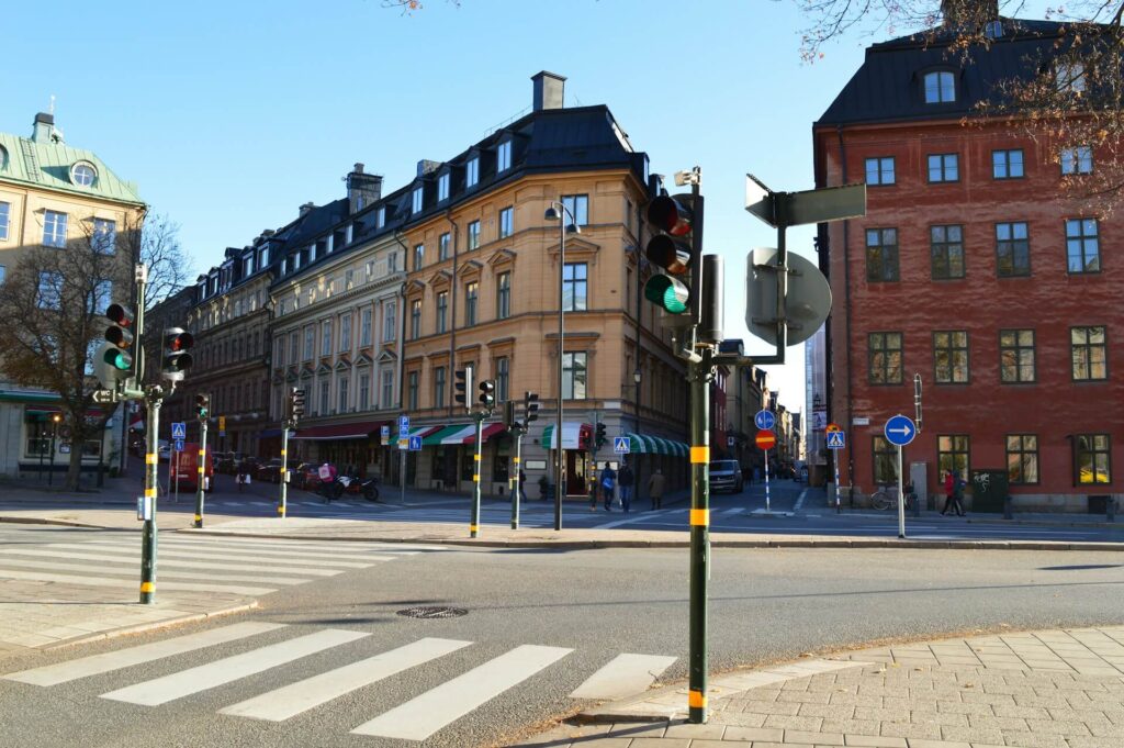 Tom gatukorsning med trafikljus, skyltar och flera färgglada lägenhetsbyggnader